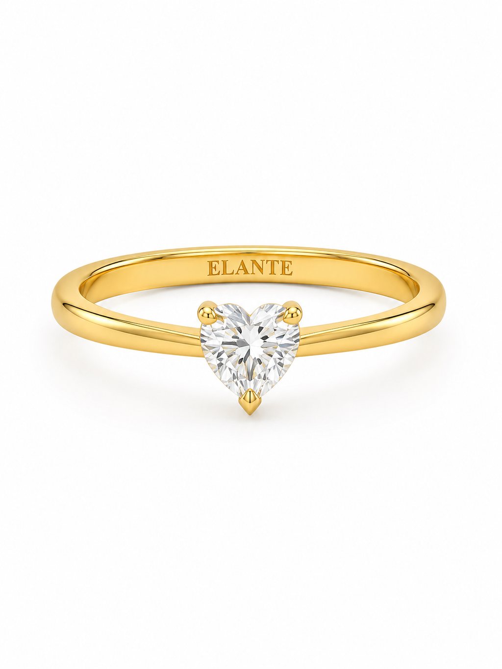 A yellow gold solitaire engagement ring featuring a heart-shaped Lab diamond in a four-prong setting. The inner band of the ring is engraved with the brand name 'ELANTE'.