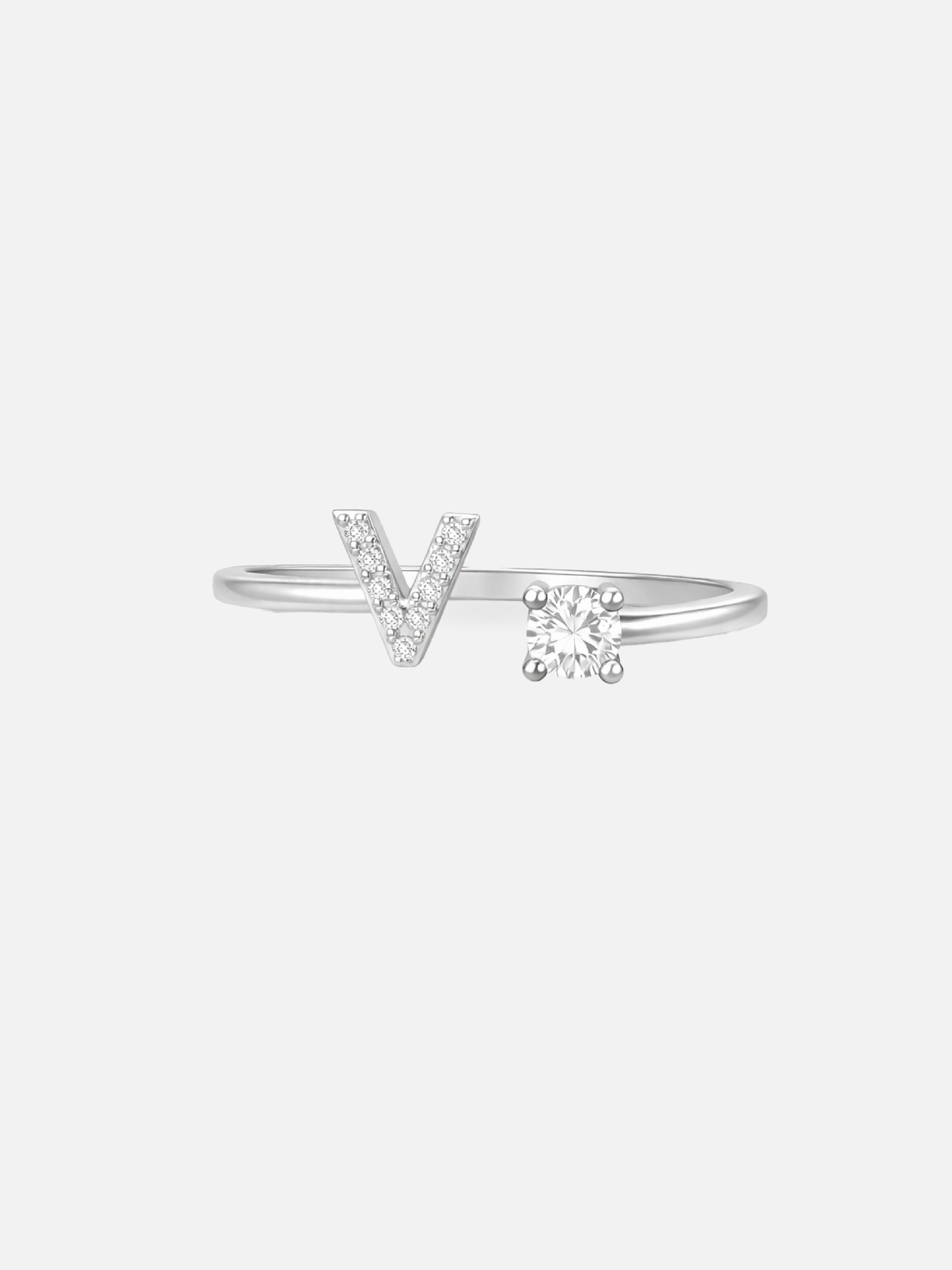 Silver ring with a 'V' and diamond on a light gray background