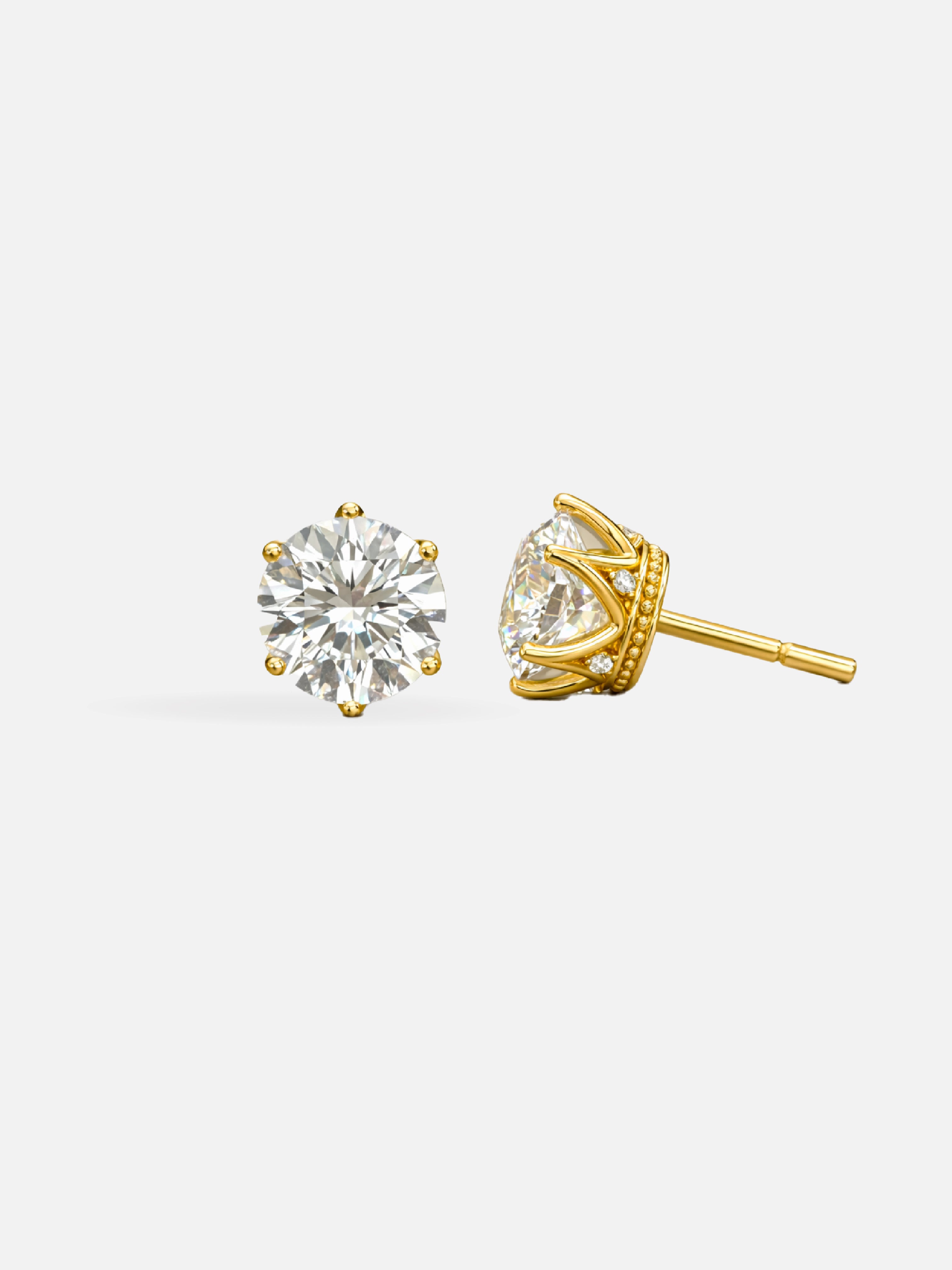 Gold stud earrings with clear gemstones on a white background