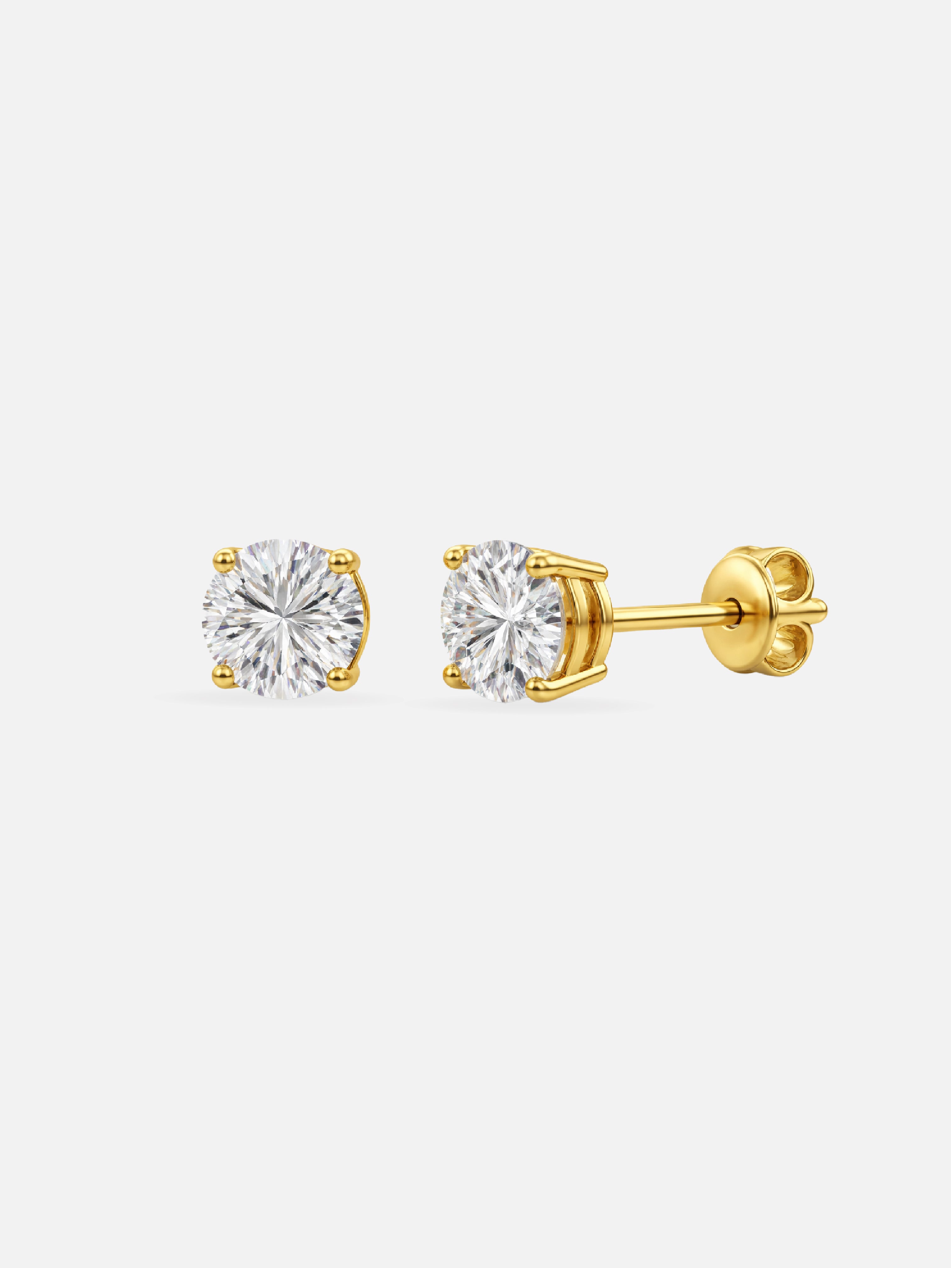 Gold stud earrings with clear gemstones on a white background